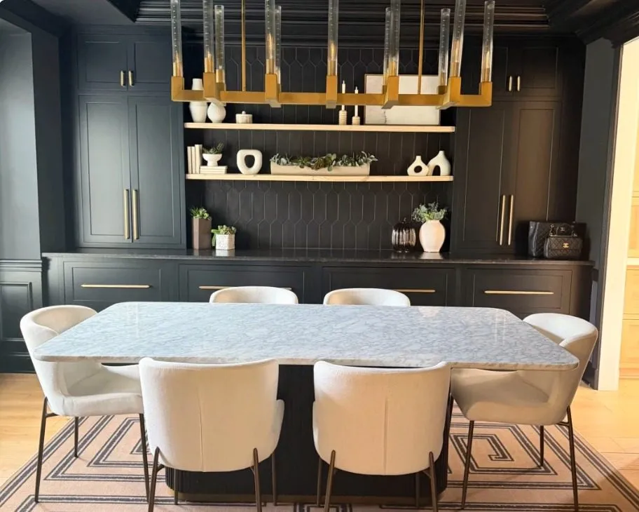Black dining room with marble table and brass chandelier