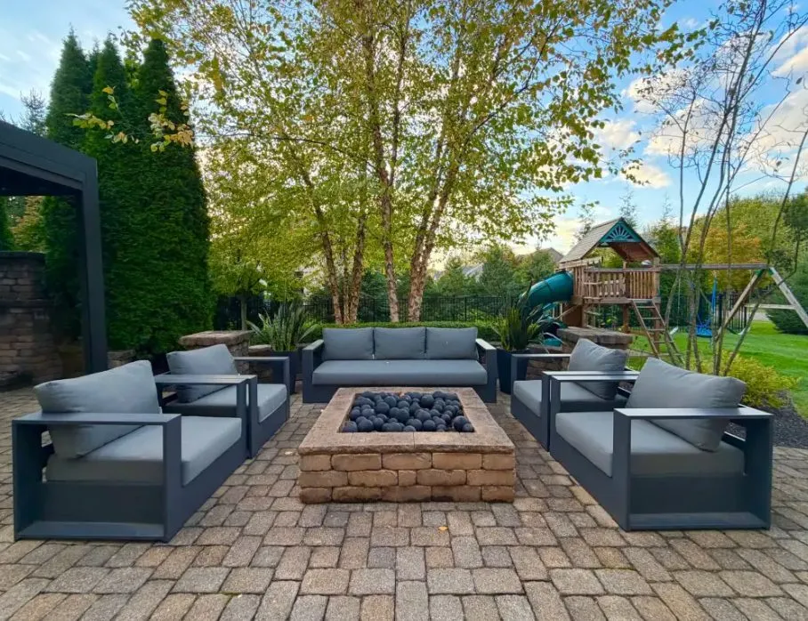 Patio fire pit ringed with charcoal lounge chairs